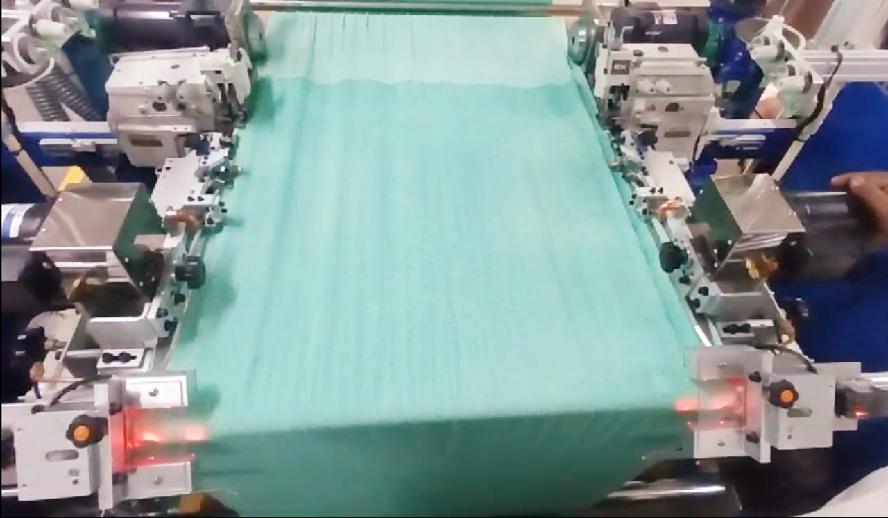 Dual heavy duty sewing heads and caterpillar feed system on Bando length hemmer